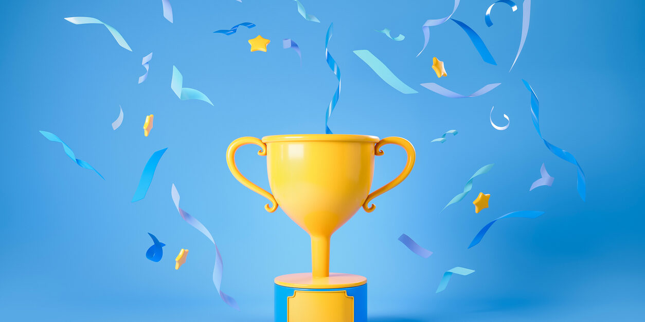 Gold cup with falling confetti on blue background, winner trophy