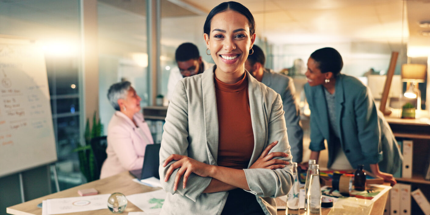 Face, business and woman with arms crossed, smile and career with teamwork, meeting or planning. Portrait, person or employee with cooperation, staff or professional with brainstorming in a workplace